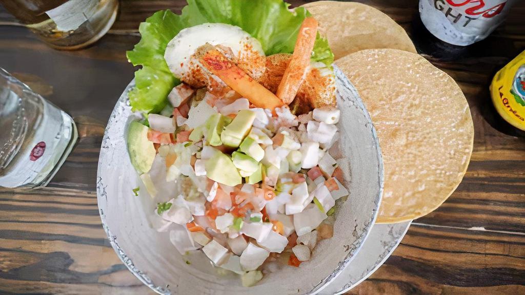 Fish Ceviche · Small pieces of fresh fish filet cooked in lime juice with diced tomato, onions, and cilantro topped with fresh avocado.