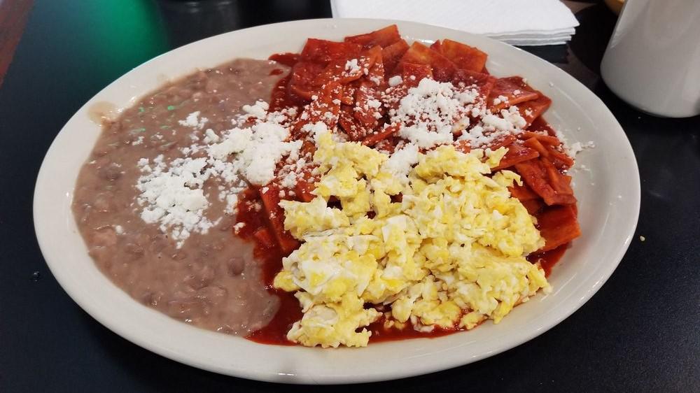 Chilaquiles Rojos · Fried tortilla, two eggs any style, topped with queso fresco. Beans on the side.