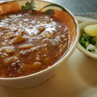 Menudo · Served with a side of diced onions, lemons, and two tortillas.