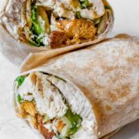 Grilled Chicken Caesar Wrap · Sliced grilled chicken with lettuce, croutons, parmesan cheese, and Caesar dressing on a whi...