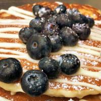 Blueberry Cheesecake · Three blueberry pancakes topped with blueberries, cream cheese and powdered sugar.