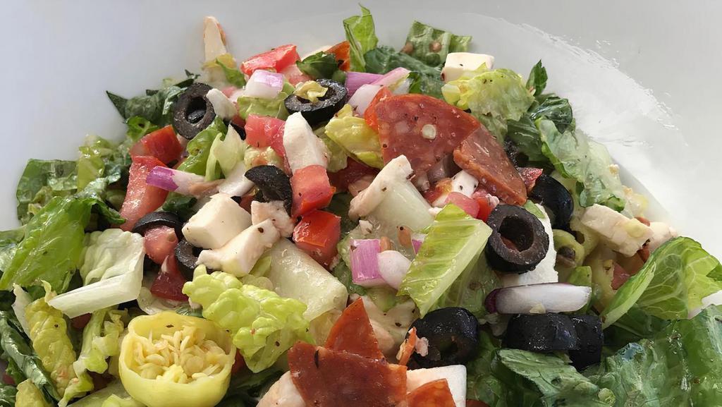The Chopped · Pepperoni, fresh mozzarella, tomatoes, olives, onions, pepperoncinis and romaine lettuce tossed with a housemade vinaigrette.