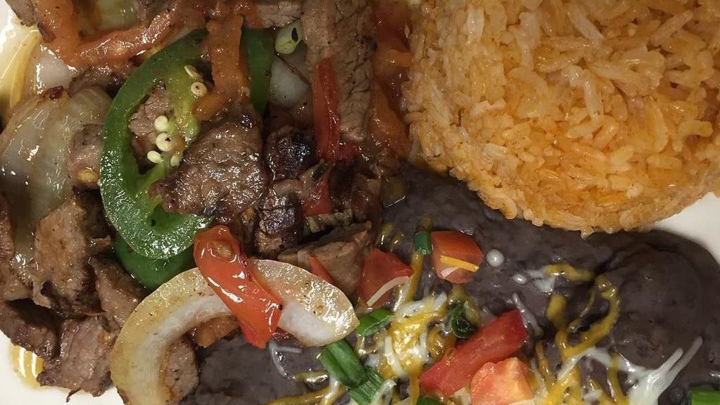 Alambre · Seared steak, baby shrimp, chorizo sausage with onions, peppers and Oaxaca cheese roasted in a cast iron skillet served with Mexican rice, refried beans and flour tortillas.