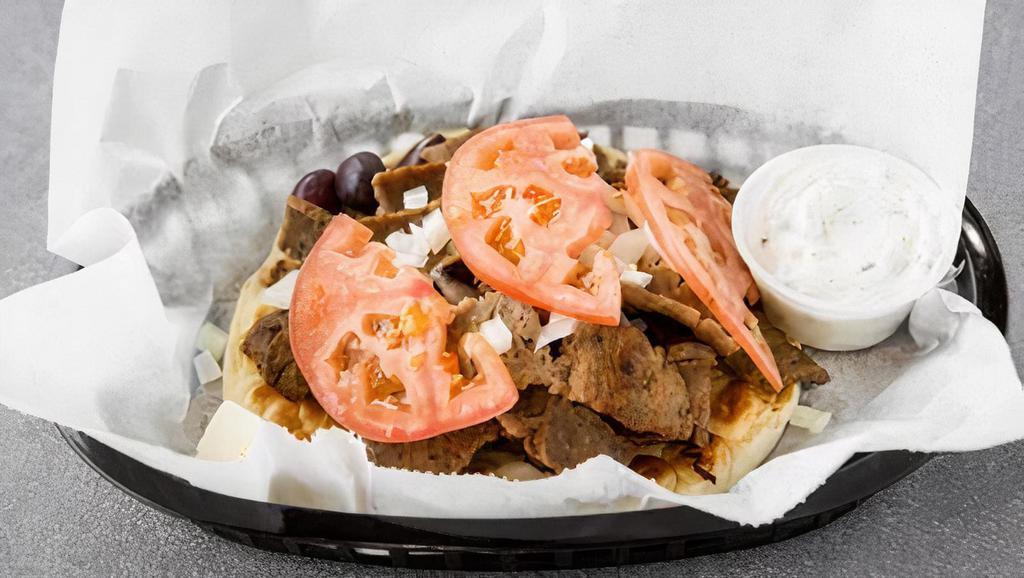 Gyro Sandwich · Pita, gyro meat, raw onions, tomatoes, feta cheese, olives, and a side of gyro sauce.