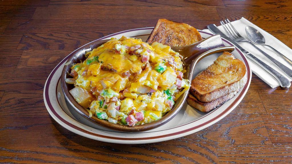 Skillet Breakfast · Scrambled eggs, potatoes, ham, onion, green pepper and cheddar cheese served with toast.