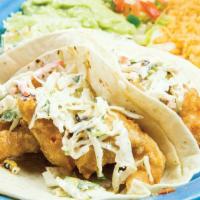 Maria’S Fish Tacos · Two fish tacos topped with cheese and homemade chipotle sauce. Served with black beans, lett...