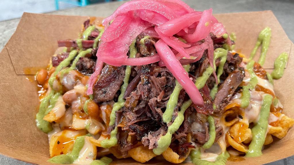 Bbq Frito Pie · Fritos topped with chili, pulled pork, bbq sauce, queso, salsa verde, & pickled onions