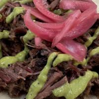 Brisket · Smoked brisket with pickled onions and salsa verde, served on Flores beef fat flour tortillas