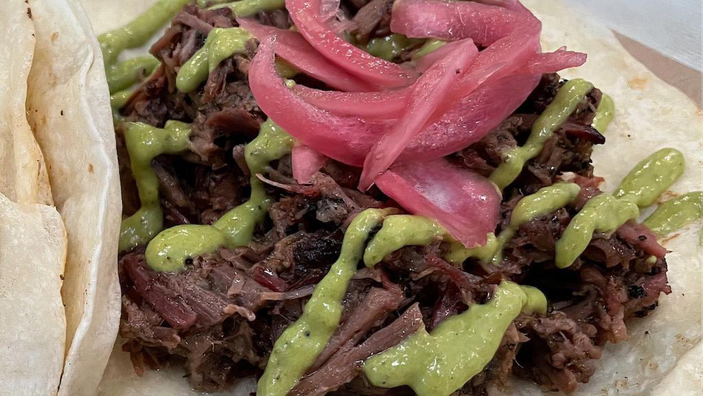 Brisket · Smoked brisket with pickled onions and salsa verde, served on Flores beef fat flour tortillas