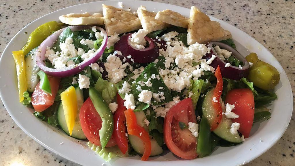 Greek Village Salad · A variety of tomatoes, cucumber, red onions, mixed sweet peppers, chickpeas, kalamata olives and feta cheese, topped with yia yia's dressing and pita bread.