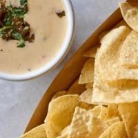 Chips & Queso & Salsa (Veg) · Spicy White Queso topped with Salsa, served with Salsa Verde and Warm Tortilla Chips