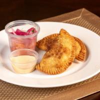 Empanadas · Two fried pastries stuffed with chicken or beef tinga.
