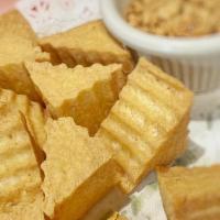 Tofu Triangles · Deep-fried tofu served with sweet and sour sauce topped with ground peanuts.