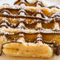 Nutella Waffles · Crispy golden baked waffles topped with Nutella and served with a side of maple syrup.