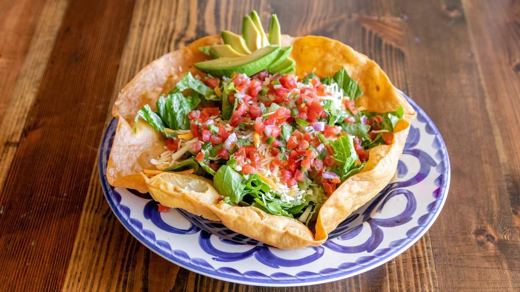 Taco Salad · crispy taco bowl, tomatoes, avocado, salsa, cilantro, jalapeno-lime dressing, mexi-queso, romaine lettuce