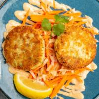 Crab Cakes · House-made blue crab cakes served over shredded carrot and jicama slaw with remoulade sauce.