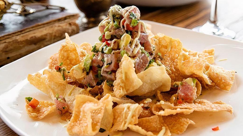 Tuna Tartare · sushi-grade tuna, peppers, onions, cilantro, lime wasabi creme. over fried wontons or spinach