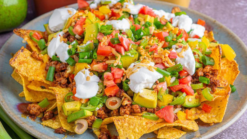 Combo Nacho Supreme · Delicious bean and cheese nachos with your choice of ground beef and shredded chicken, a side of guacamole, sour cream and jalapeños.