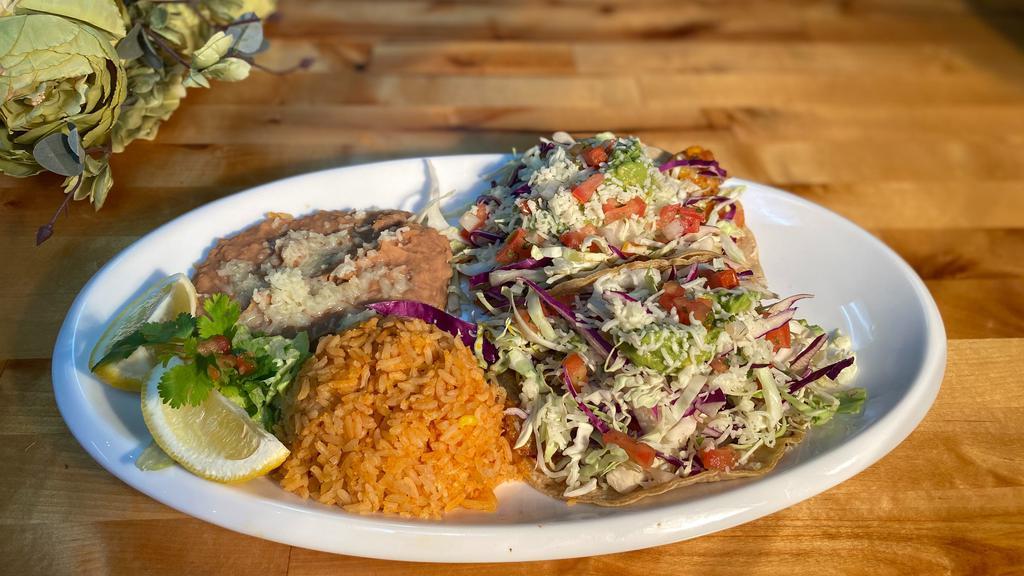 Fish Tacos Combo Plate (Fried, Grilled, Or Vegan) · Two fish tacos grilled or fried seasoned with our house spices topped with white sauce, cabbage, pico de gallo, guacamole, and cheese in a corn tortilla. served with your choice of side.