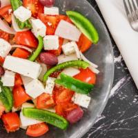 Horiatiki · Greek village salad. Tomatoes, cucumbers, peppers, onions, feta, and capers tossed with oliv...