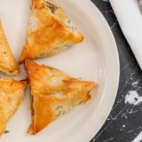 Spanakopita · Spinach pie. A large turnover of filo dough stuffed with spinach, cheeses, onions and baked ...