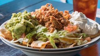 Super Nachos · Our handmade corn tortilla chips are heaped with refried beans, chicken tinga, Cheddar, guac...