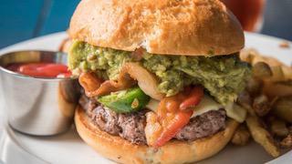 Wild Guacamole Burger · 8 oz black Angus beef, grilled, topped with cheese, caramelized onions, guacamole, bacon, an...