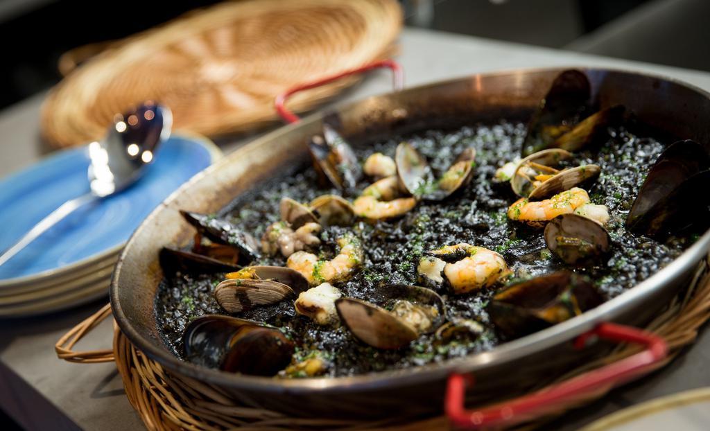 Paella Negra  · squid ink-seafood stock, cod/halibut,  mussels, clams, shrimp, sofrito, picada sauce