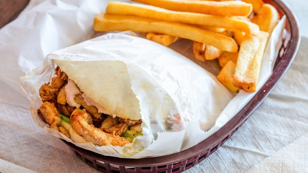Chicken Shawarma · Shredded thigh meat, garlic sauce, lettuce, tomatoes, pickles, and tahini sauce.