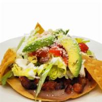 Tostada · Crunchy homemade tortilla flat, topped  with refried beans, the meat of your choice and salad.