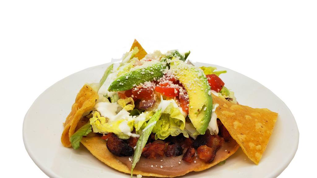 Tostada · Crunchy homemade tortilla flat, topped  with refried beans, the meat of your choice and salad.