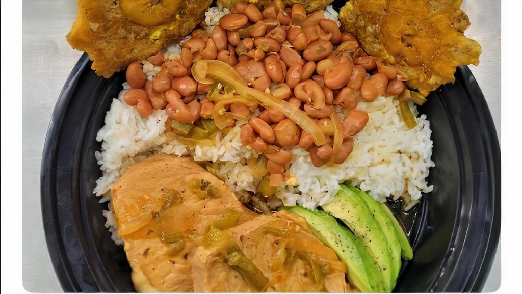 Pork Chops Guisado Plate · 2 boneless pork loin chops seasoned with Puerto Rican spices and slowly cooked in broth. Served with rice of the day, 1⁄4 avocado and 3 tostones.