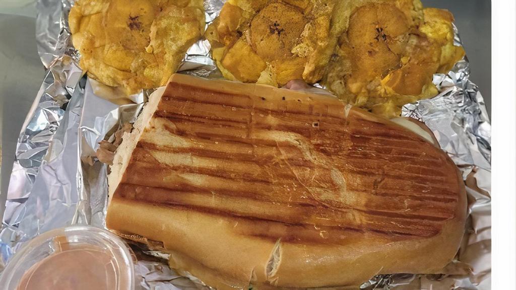 Cuban Sandwich Combo · 1⁄2 lb of pork shoulder marinated in Puerto Rican spices then slowly roasted, with ham, Swiss cheese, pickles and mustard in fresh sub bread pressed and toasted to perfection. Served with you choice of 3 tostones or a bag of potato chips.