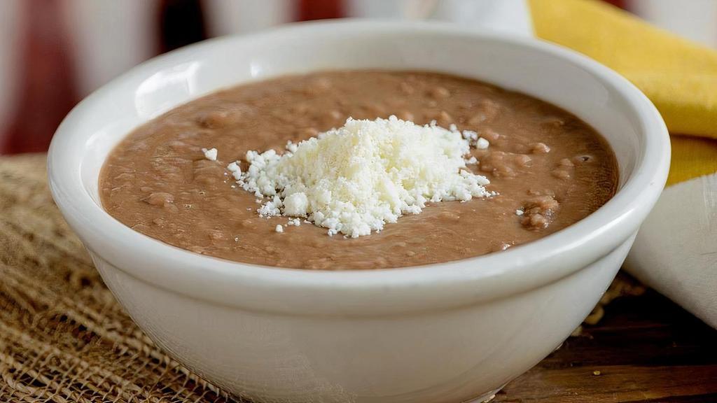 Refried Beans · Refried pinto beans topped with cotija cheese. (Vegan when ordered without cheese.)