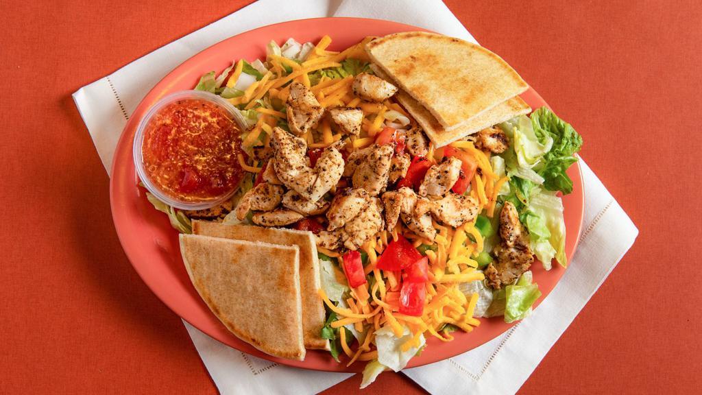 Chicken Fajita · Fajita spiced grilled chicken, cheddar, onion, green peppers and tomato over mixed greens with tomato vinaigrette dressing and grilled pita.