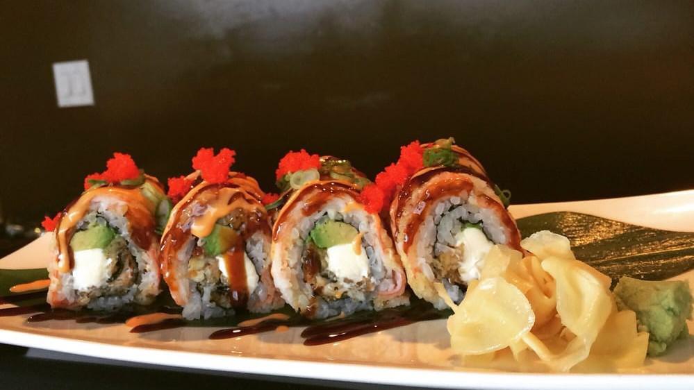 Dragon Roll (Cooked) · Grilled eel and cucumber inside, topped with fresh avocado and tobiko. served with eel sauce.
