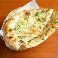 Garlic Naan · White bread baked in tandoor (clay oven) with a touch of garlic