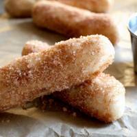Cinnamon Bread Sticks · Fresh dough baked to a golden brown. Crusty on the outside and soft on the inside. Drizzled ...