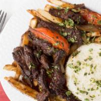 Lomo Saltado · Beef tender steak sautéed in oil with onion and tomatoes, served with white rice and French ...