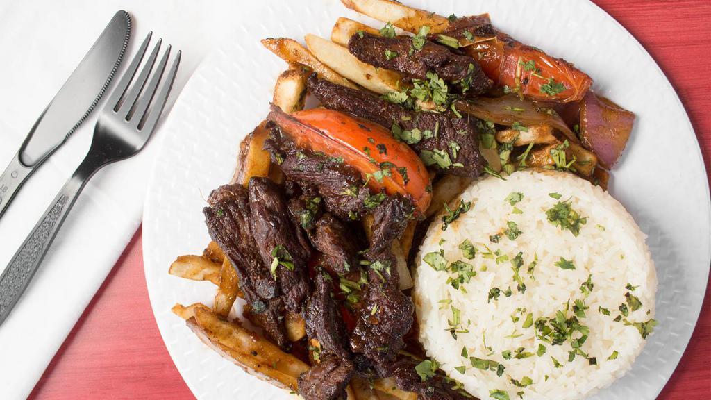 Lomo Saltado · Beef tender steak sautéed in oil with onion and tomatoes, served with white rice and French fries.