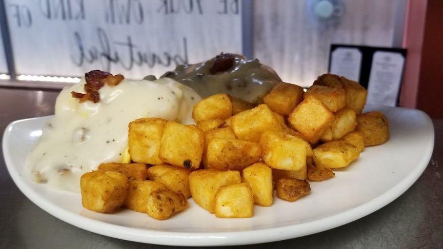 Texas Benny · Two fresh cracked scrambled eggs on top of a warm biscuit piled with sausage patties or bacon covered with our house sausage gravy.