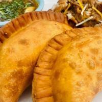 Birria Empanadas · Slow braised beef, monterey jack cheese, cilantro and onions. served with a rich consome.