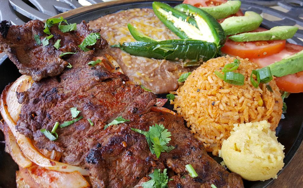 Carne Asada Platillo · Eight ounces of butterfly steak grilled with onions, served with cilantro, sliced tomatoes, avocados, and jalapeños. served with fresh limes, refried beans, rice, and choice of tortillas.