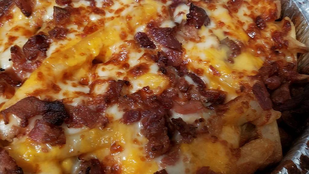 Loaded Fries · Fries layered with cheddar & mozzarella with bacon and baked in the oven to golden perfection.