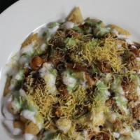 Samosa Chaat  · Crispy vegetable turnover served on the bed of mildly spiced chickpeas.