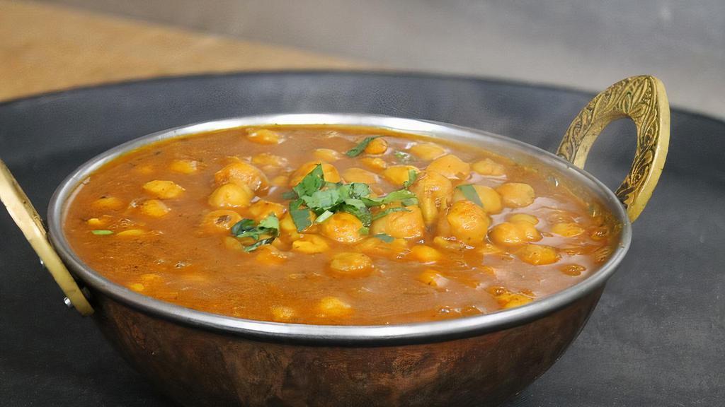 Chana Masala  · Spicy garbanzo beans slow cooked with onions, tomatoes, ginger, garlic and spices.