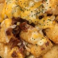 Tots Skillet · Crispy tots topped with melted shredded cheese and bacon. Served with spicy ranch