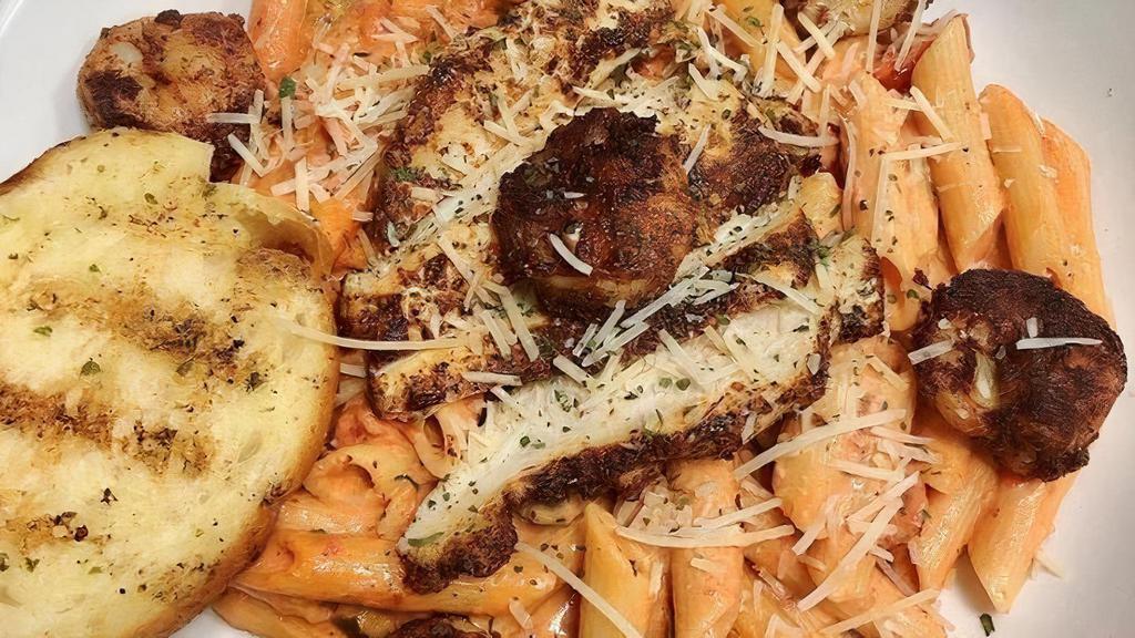 Cajun Chicken & Shrimp Pasta · Grape tomatoes, bell peppers and penne pasta tossed in a creamy rose sauce; topped with blacked chicken and shrimp. Served with garlic bread
