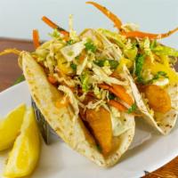 Baja Fish Tacos · Tempura battered mahi-mahi fillet wedges (2) layered with a house-made tropical cabbage slaw...