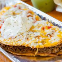 Tostada Grande · Flour tortillas fried flat, layered with your choice of beef, refried beans or a combination...
